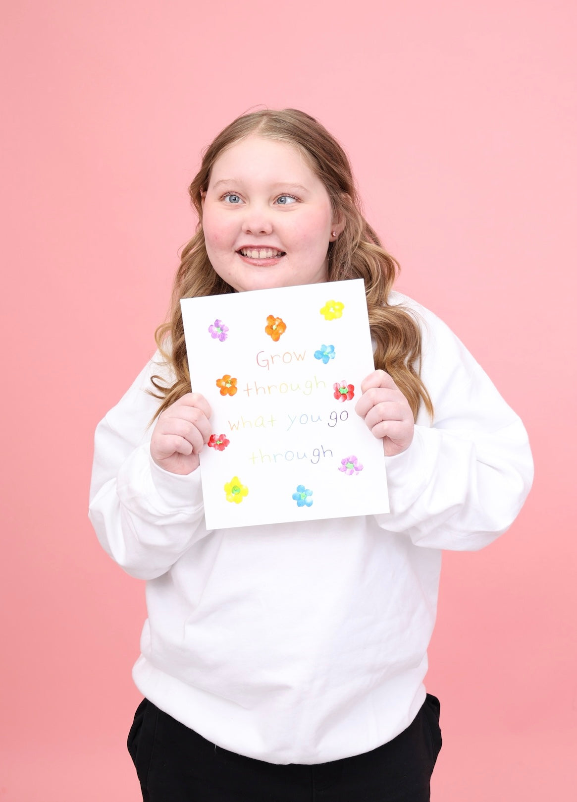 Charlotte holding her colourful Grow Through What You Go Through artwork